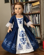 A 18-inch doll in a colonial formal decorated with embroidery