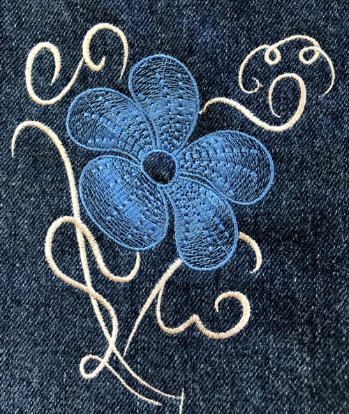 Jeans embroidered with the designs from Swirls and Flowers Set. Close-up of the embroidery.