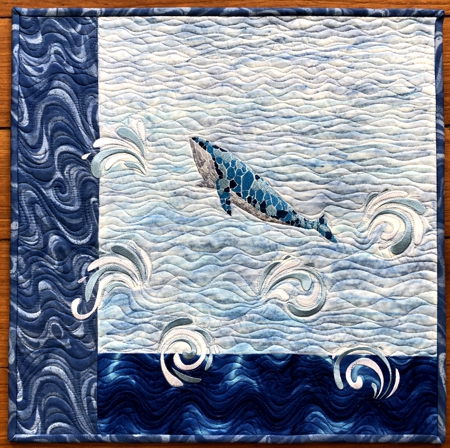 Finished quilt with whale embroidery.