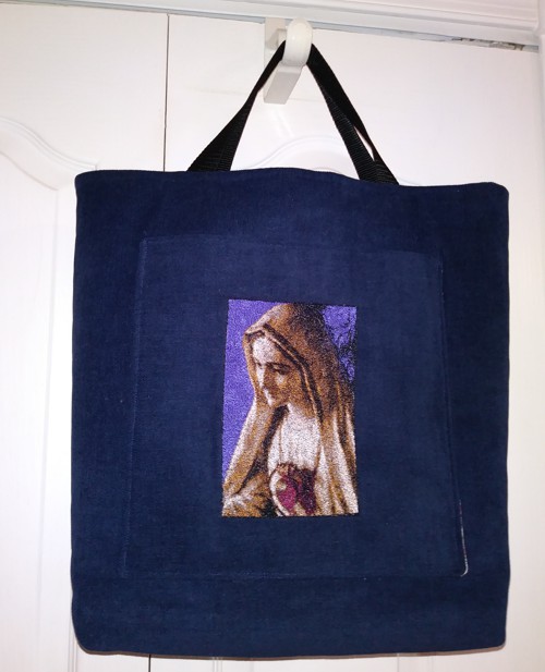 A black tote bag with Virgin Mary embroidery