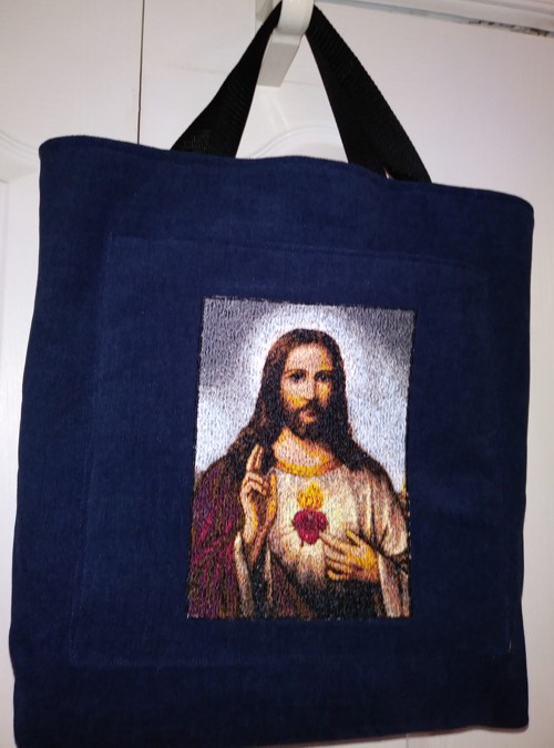 A black tote bag with Jesus embroidery.