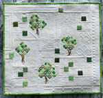 White quilt with green tree embroidery