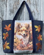 A roomy tote bag with embroidery of a corgi dog and fall leaves on the front panel