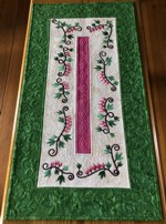 A quilted tablerunner with bleeding heart flowers embroidery