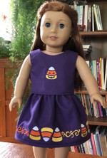 A skirt and a top with candy corn embroidery for a 18-inch doll.