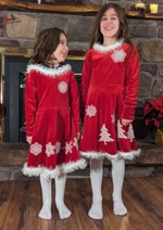 2 little girls in red dresses decorated with white winter-themed embroidery