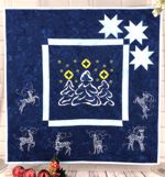 Royal blue quilt with embroidery of Christmas trees and reindeer.