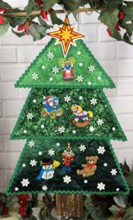 Quilted wallhanging in shape of a fir tree with embroidery as ornaments.