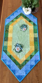 Blue and green quilted tablerunner with daidy embroidery.