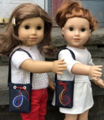 2 dolls with embroidered hand bags