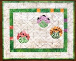 Small wall quilt in cream and green colors with flower embroidery