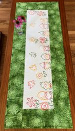 Tablerunner with green borders and garden gnomes embroidery on the central part