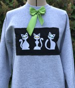 A gray Sweat-shirt with cat embroidery and a green bow.