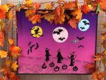 Wall quilt with embroidery of witches, moons, bats and jack-o-lanterns.