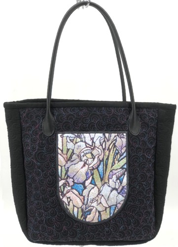 Quilted tote bag with iris embroidery on the front pocket.