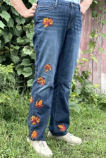 A pair of jeans decorated with leaves embroidery