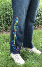 A pair of blue jeans embellished with embroidery