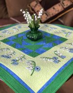 Quilted tabletopper with lily of the valley embtoidery