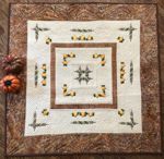 Quilted tabletopper with pumpkin embroidery.
