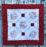 Red-and-white wall quilt with bird embroidery