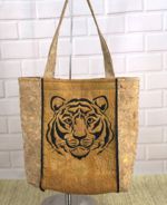 A tote bag made of cork with a quilted front panel and embroidery of a tiger.