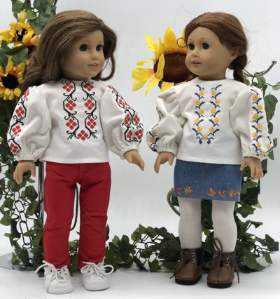 Two 18-inch dolls in folk style blouses with cross-stitch embroidery