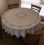 Tablecloth embroidered with cutwork rose designs.