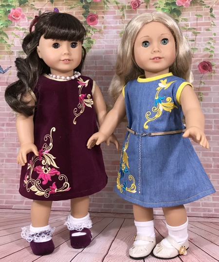 Two 18-inch dolls modeling the machine embroidered dresses