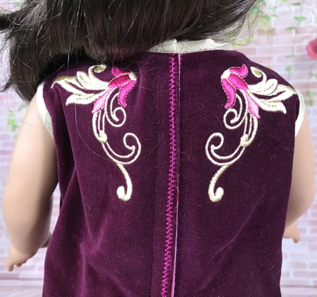 18-inch doll modeling the machine embroidered dress, back view