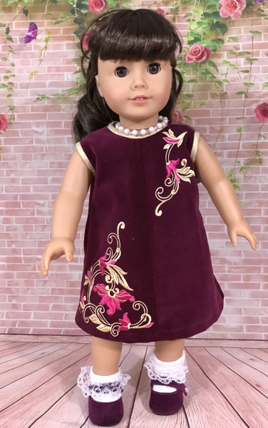 18-inch doll modeling the machine embroidered dress