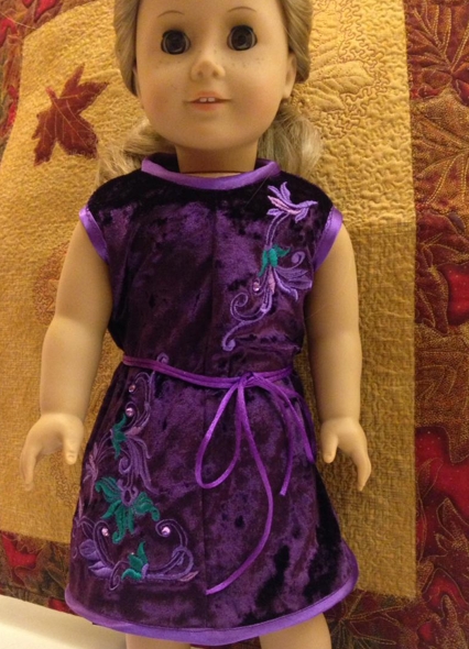 A 18-inch doll modeling the machine embroidered dress