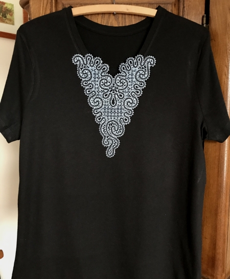 Photo of the T-shirt with V-neck and a stitch-out of the design stitched over the V-neck.