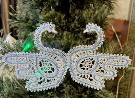 Photo of the two stitch-outs of the first swan design on a Christmas tree branch