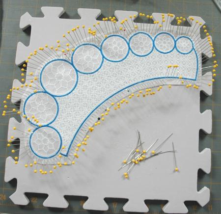 Photo demonstrating how to pin a stitch-out to a foam board to wash out the stabilizer.