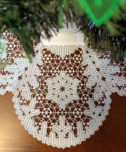 A close-up photo of the lace under a small Christmas tree
