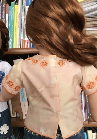 Photo showing the back of the blouse on a doll