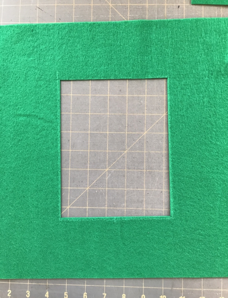 Piece of felt with cut-out rectangle in the center.