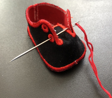 Photo showing how to insert laces into the doll shoe.