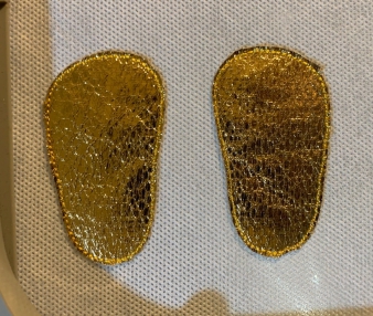 Outlines of shoe soles with the fabric cut around.