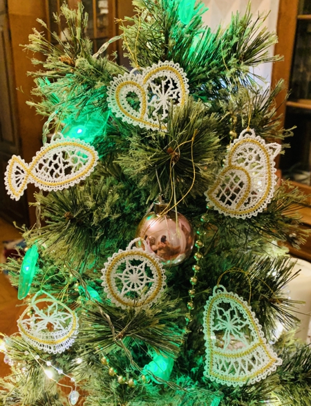 Stitch-outs of 6 ornaments of the set on a Christmas tree.
