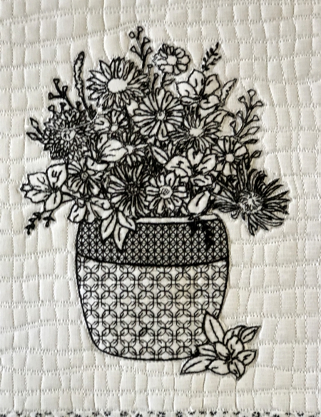 Close-up of the embroidery: flowers in a vase.
