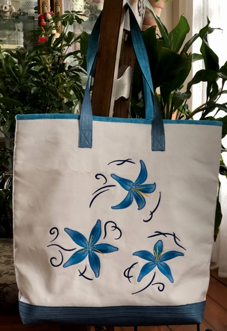 Finished white canvas bag with blue lilies embroidery.