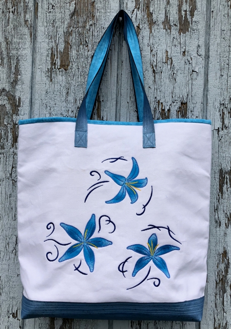 Finished white canvas bag with blue lilies embroidery.