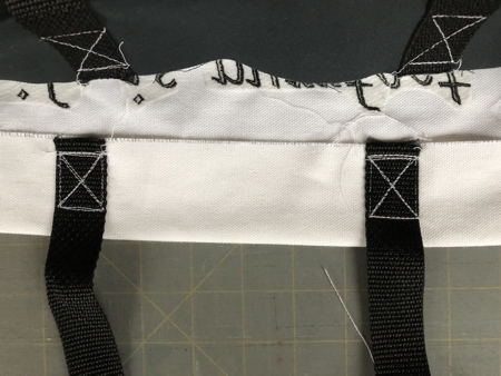 Fold the upper edges back by pressed line. Topstitch the handles in place.
