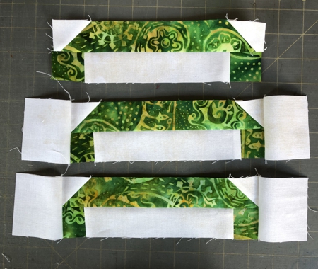 Sew the green strips with light corners to the light strips with green ends. You'll get 4 new strips.