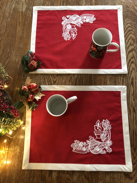 Finished placemats - red fabric and white embroidery.