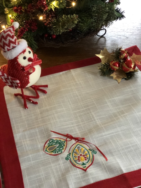 Finished placemats - white fabric, red binding and multi-colored embroidery