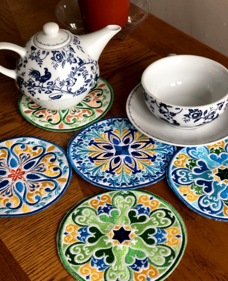 Finished coasters on a table with a tea cup and tea pot.