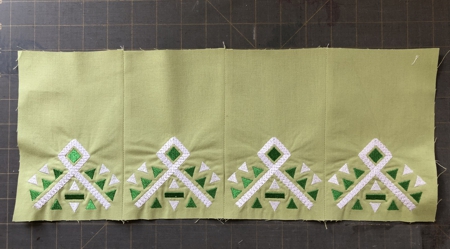 The skirt stitch-outs sewed together in a strip.