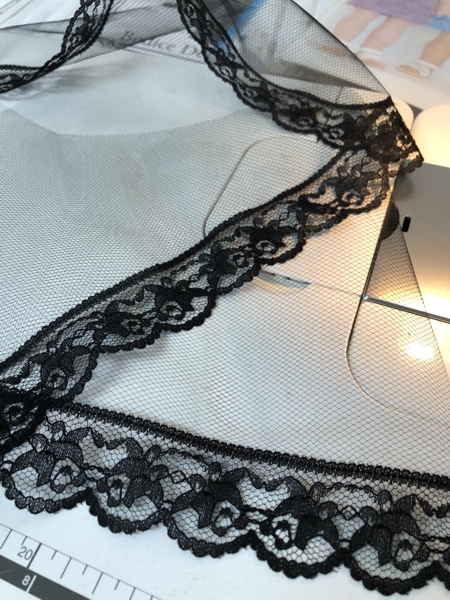 Lace stitched to netting.